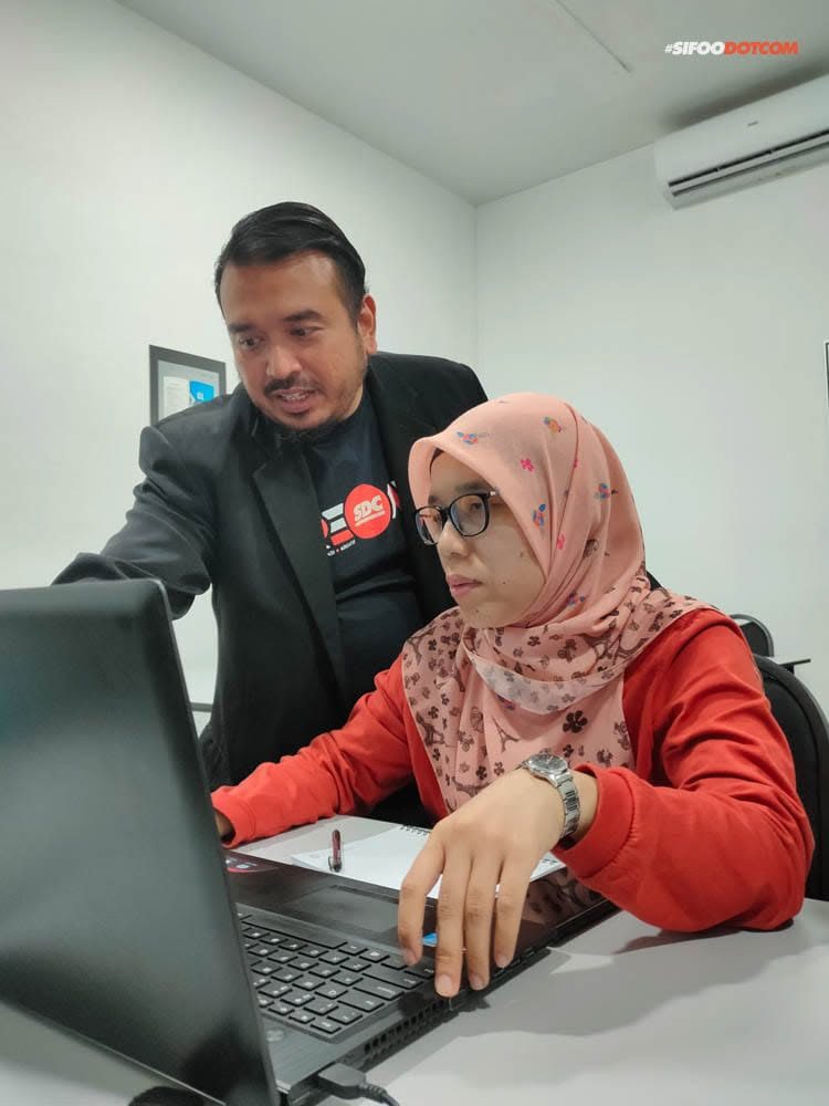 Norzaful guiding a participant at her laptop
