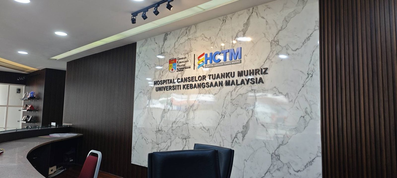 HCTM and UKM signage on a marble wall