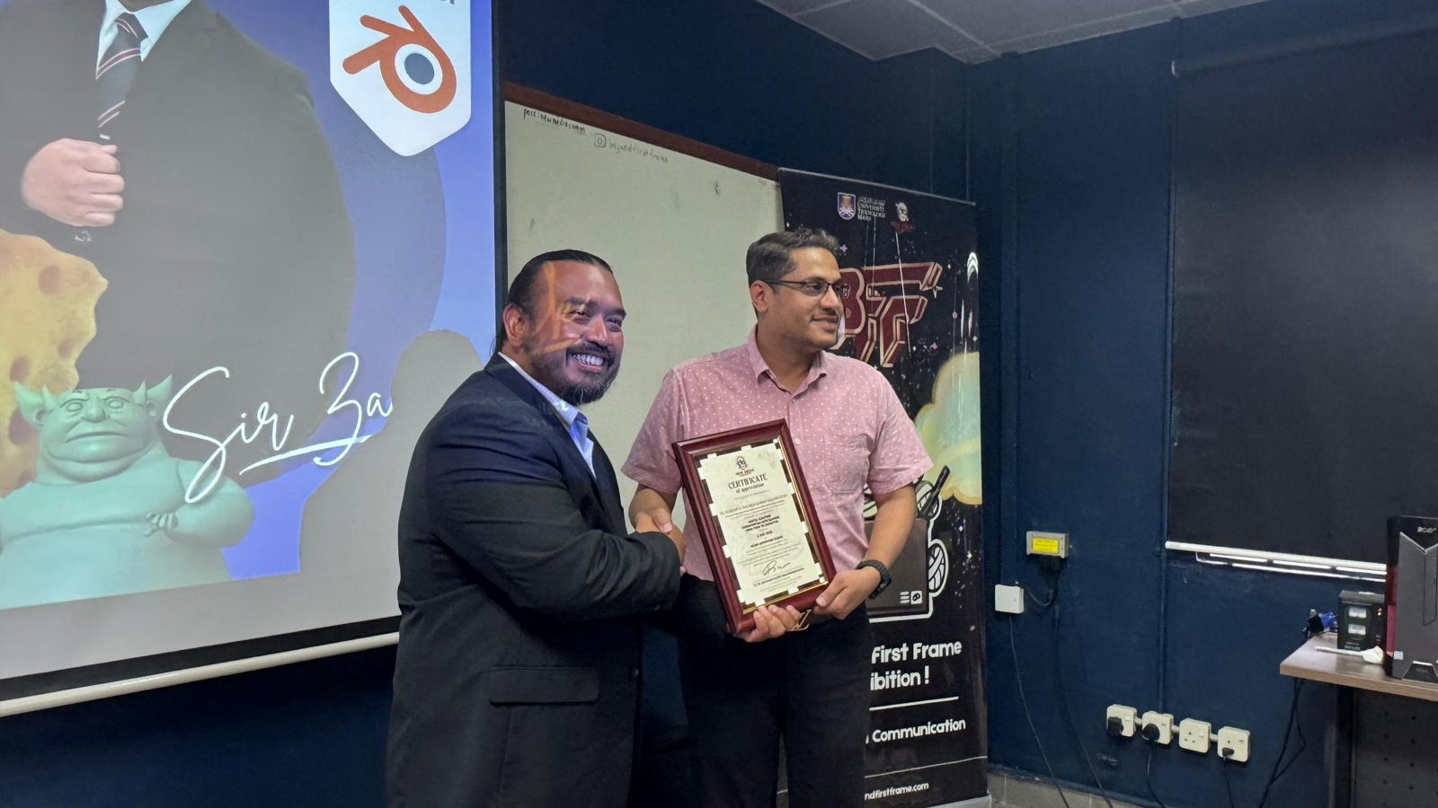 Norzaful receiving a framed certificate of appreciation